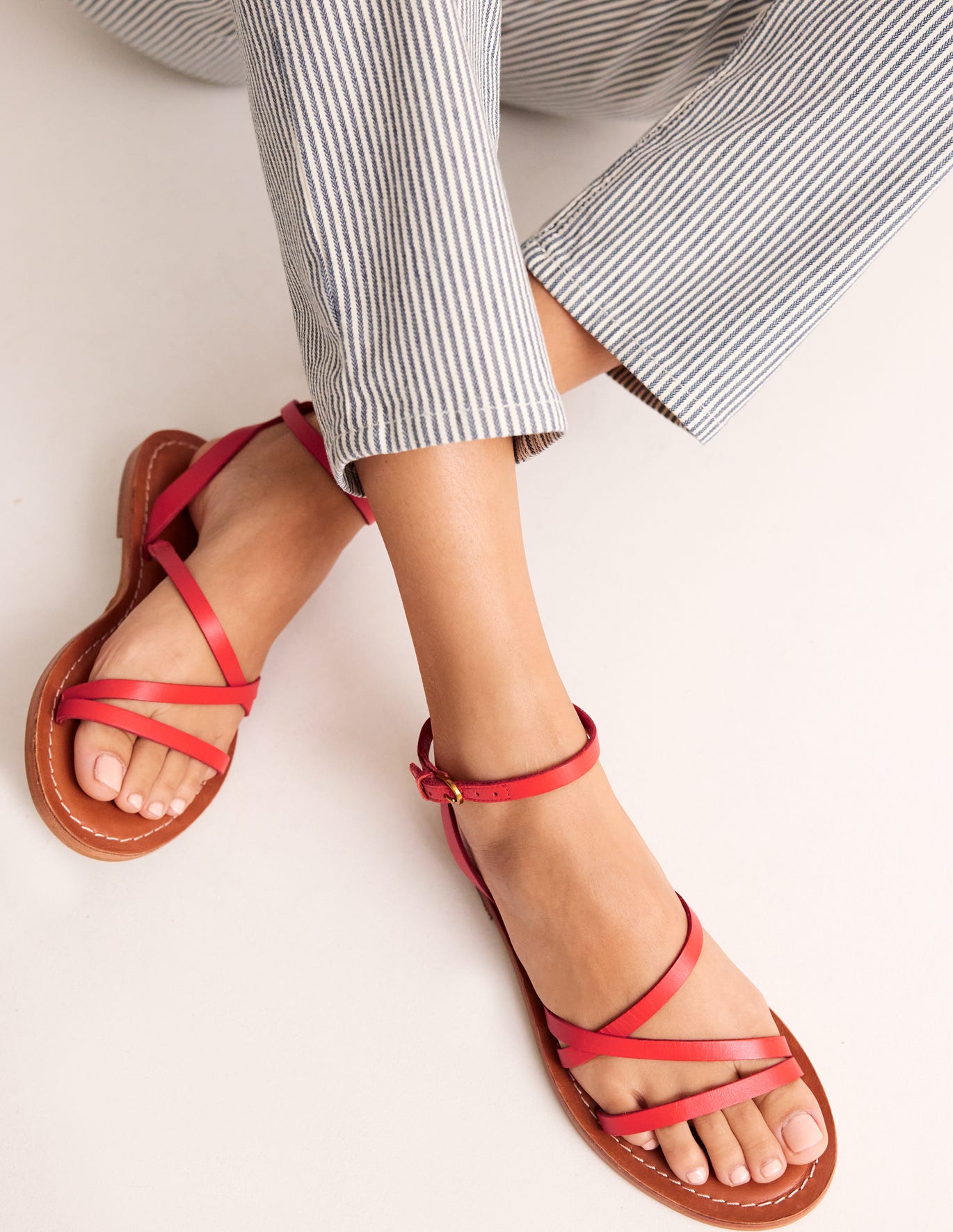 Boden red leather strappy sandals with flat leather sole and buckle ankle fastening. 